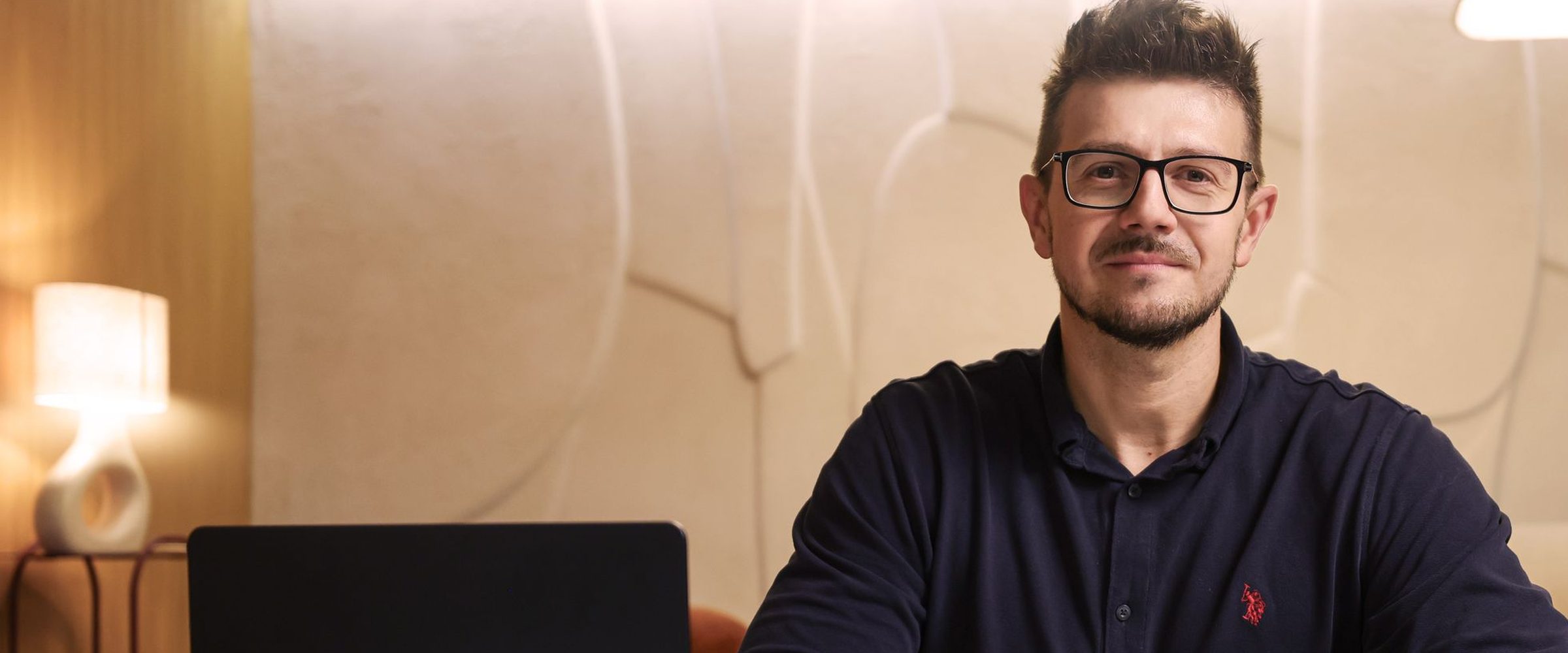 Marcin Wróbel przy biurku z laptopem